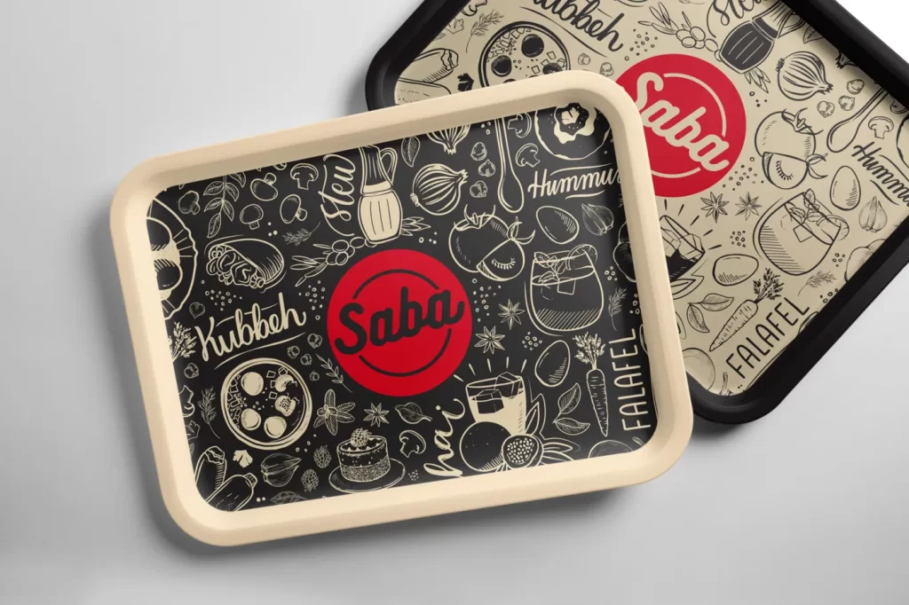 Dos papeles de bandeja (tray liners) del restaurante Saba con ilustraciones de ingredientes y lettering de Hummus, Kubbeh y Falafel